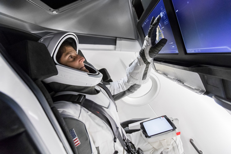 &quot;NASA astronaut Suni Williams, fully suited in SpaceX’s spacesuit, interfaces with the display inside a mock-up of the Crew Dragon spacecraft.&quot;