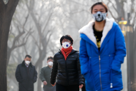 Chinese people wearing masks for protection against pollution walk at Ritan Park shrouded by heavy smog in Beijing, Monday, Dec. 19, 2016. Chinese cities are limiting the number of cars on roads and have temporarily shut down factories to cut down pollution during a national &quot;red alert&quot; for smog. (AP Photo/Andy Wong)