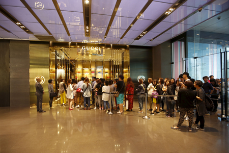 Customers line up as they wait to go inside a Gucci shop at a shopping mall in Shanghai, May 27, 2015.