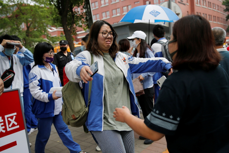 A crying student walks towards her family member after the annual national college entrance exam in Beijing, China