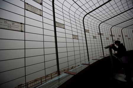 A visitor is silhouetted at an observatory tower during a polluted day in Beijing January 15, 2015. Beijing issued its first smog alert of 2015 on Tuesday. Stagnant and humid air has aggravated the city&#039;s air pollution, causing the smog to linger, according to Xinhua News Agency. REUTERS/Kim Kyung-Hoon (CHINA - Tags: ENVIRONMENT)