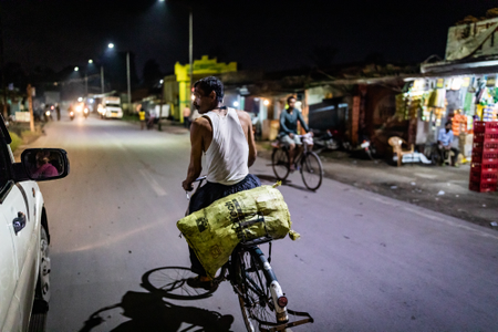 A mine worker carries a bag of coal back home on his bicycle in Korba.