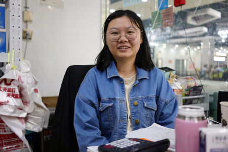 Siyuan Wang, the 27-year-old medical equipment shop owner, sits at her desk at Khorgos ICBC.