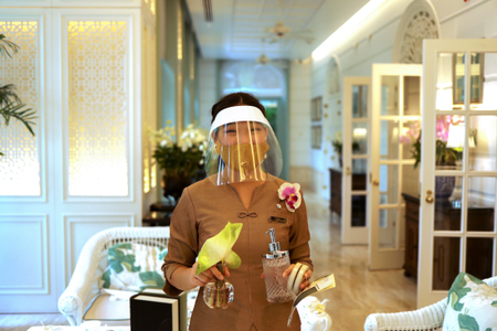 A waitress wearing a protective mask and face shield reacts at the Mandarin Oriental hotel, after the government eased some protective measures following the coronavirus disease (COVID-19) outbreak, in Bangkok, Thailand July 7, 2020. REUTERS/Jorge Silva