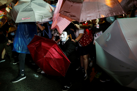 A protester wears Guy Fawkes mask during a confrontation with the police outside China Liaison Office in Hong Kong, China, November 6, 2016. REUTERS/Bobby Yip - RTX2S652