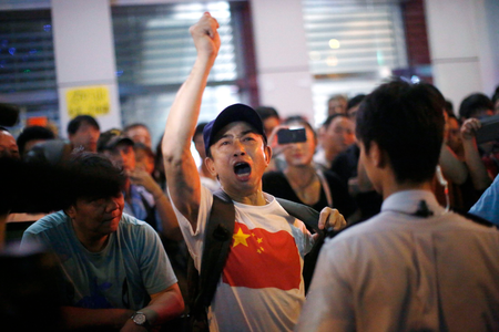 An anti-Occupy Central protester argues with pro-democracy protesters on a main street at Hong Kong
