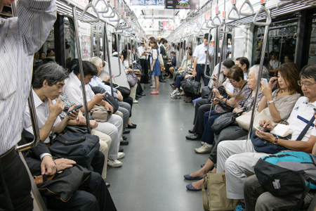 Everyone is on their smartphones in the subway in Japan.
