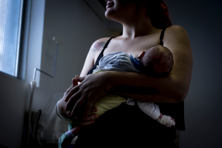 A Brazilian mother holds her newborn, who was infected with syphilis during pregnancy. A shot of penicillin would had been enough to treat both of them.