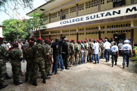 Guinean soldiers and civilians queue to cast their votes in Conakry.