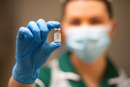 A nurse holds a vial of the Pfizer/BioNTech Covid-19 vaccine