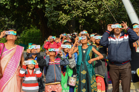 Students and teachers on the outskirts of Ahmedabad, India, watch the eclipse.