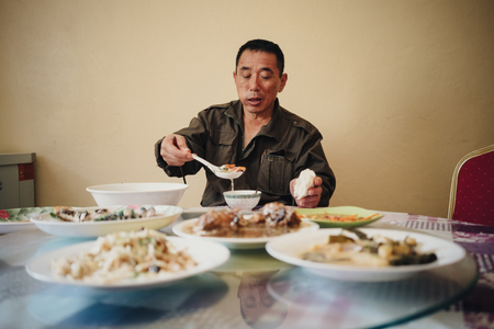 Liu Zhaoquan, who works in a fish meal factory in Nouadhibou, Mauritania, eats Chinese dishes from his native Shandong province in the factory canteen. Liu returns home only once every two years. The canteen food is one of the few reminders of home.
