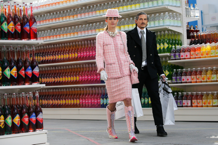 Models present creations by German designer Karl Lagerfeld as part of his Fall/Winter 2014-2015 women&#039;s ready-to-wear collection for French fashion house Chanel at the Grand Palais transformed into a &quot;Chanel Shopping Center&quot; during Paris Fashion Week March 4, 2014.