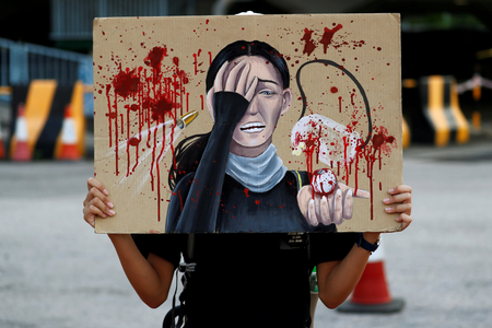 A student holds a placard honouring the woman that was shot in the eye at a protest, during a rally to call for political reforms outside City Hall in Hong Kong, China, August 22, 2019.