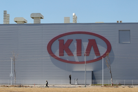 A man walks past the logo of Kia Motors at the manufacturing plant in Pesqueria, on the outskirts of Monterrey