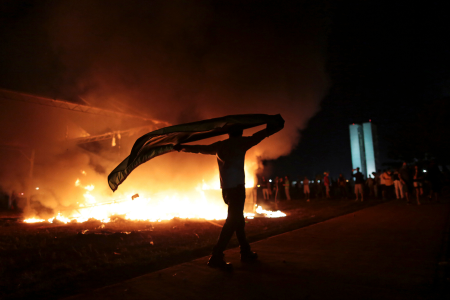 Protestor walks next to fire