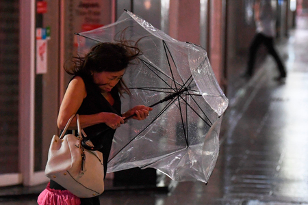 A woman holds her umbrella as wind is grows in Tokyo on Sept. 8, 2019.