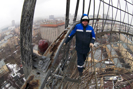 A worker stands on the Shukhov tower&#039;s rusted surface.