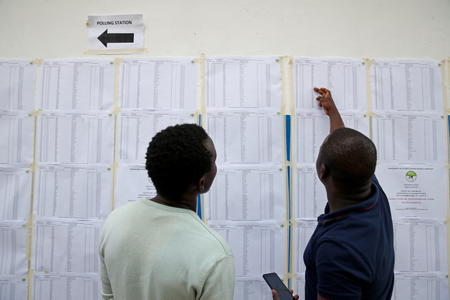 Voters search for their names on an electorate list near a polling station ahead of the presidential election, in Nairobi, Kenya August 7, 2017.