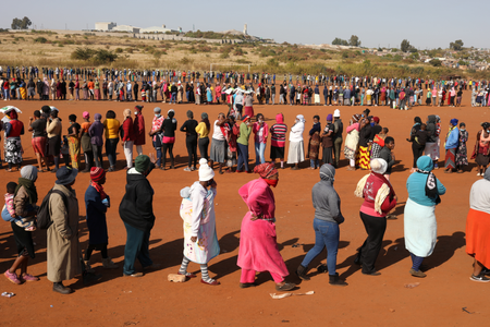 People stand in a queue to receive food aid in Pretoria.