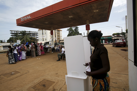 A woman casts her vote at a petrol station in Conakry.