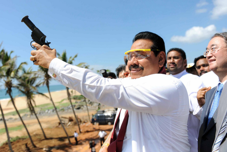 A President Media Davison handout picture shows Sri Lankan President preparing to fire a flare while special representative from China, Sang Guowei watches from behind welcoming the first ship, Sri Lanka Navy vessel Jetliner into the newly built Magampura Mahinda Rajapaksa Port which was ceremonial commissioned in Hambantota 238kms south of Colombo 18 November 2010. The first stage of the Hambantota or Magampura Mahinda Rajapaksa Port in Hambantota, build with Chinese assistance was commissioned today amidst much grandeur. Today also marks President Percy Mahendra ?Mahinda? Rajapaksa?s 65th birthday. He is to take oaths for a second term as president of the island nation tomorrow (Nov. 19) and several events are being held in commemoration.