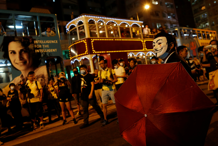A demonstrator wears a Guy Fawkes mask as he stands in front of police during a protest in Hong Kong. (Reuters/Tyrone Siu)