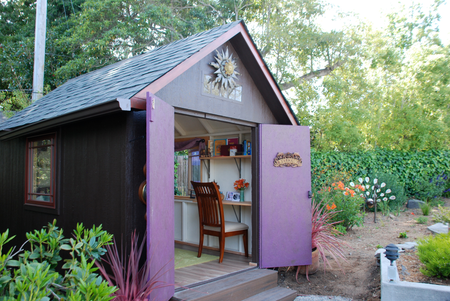 A backyard she shed with a home office inside.