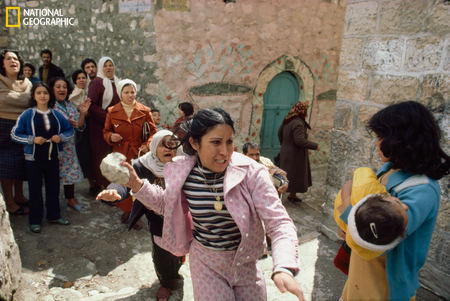 palestinian woman holding rock