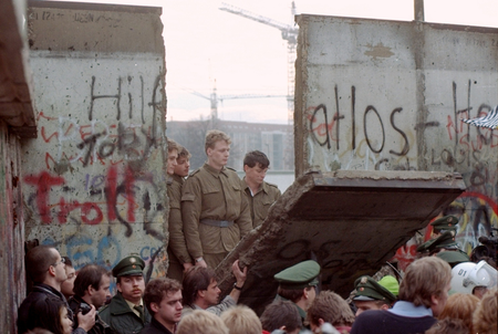 FILE - In this Nov. 11, 1989 file photo, East German border guards are seen through a gap in the Berlin wall after demonstrators pulled down a segment of the wall at Brandenburg gate, Berlin. The Berlin Wall is gone, but people can still tag their memories upon it online. The Berlin Twitter Wall, which went online Tuesday, Oct. 20, 2009 encourages people to share their memories of the wall&#039;s collapse and hopes for the future on a scrolling wall using Twitter, the social networking site.