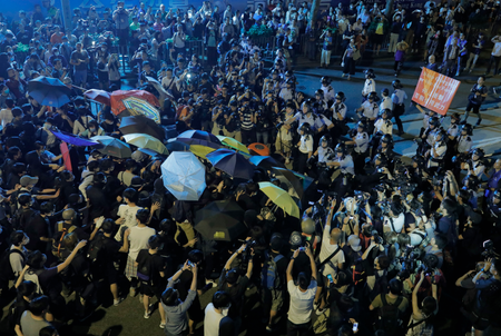 Protesters use umbrellas to block the pepper spray from office officers outside the Chinese central government&#039;s liaison office in Hong Kong, Sunday, Nov. 6, 2016. Thousands of protesters marched in Hong Kong on Sunday, demanding that China&#039;s central government stay out of a political dispute in the southern Chinese city after Beijing indicated that it would intervene to deter pro-independence advocates. (AP Photo/Vincent Yu)