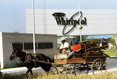 A horse-drawn carriage drives by a Whirlpool plant in Monterrey in 1993