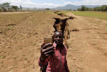 A man takes a selfie photograph near a chasm suspected to have been caused by a heavy downpour along an underground fault-line near the Rift Valley town of Mai Mahiu, Kenya March 28, 2018. Picture taken March 28, 2018.
