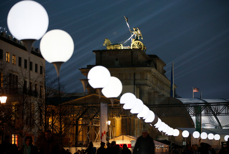 The installation &#039;Lichtgrenze&#039; (Border of Light) along a former Berlin Wall location is illuminated next to the Brandenburg Gate, at dusk in Berlin November 7, 2014. A part of the inner city of Berlin is being temporarily divided from November 7 to 9, with a light installation featuring 8000 luminous white balloons, following the 9.5-mile (15.3 kmilometre) path the Berlin Wall once occupied, to commemorate the 25th anniversary of the fall of the Wall. REUTERS/Fabrizio Bensch (GERMANY - Tags: ANNIVERSARY ENTERTAINMENT) - RTR4DA9L