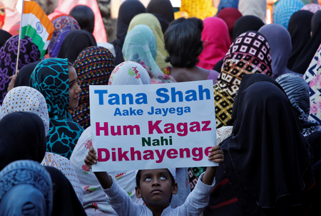 A boy holds up a placard as he attends a protest rally against a new citizenship law, after Friday prayers in Chennai