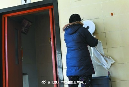 People pulling toilet papers in the restrooms at the Temple of Heaven Park in Beijing.