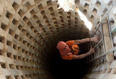 A Palestinian smuggler climbs down into a tunnel, temporarily closed by Hamas forces, beneath the Egyptian-Gaza border in Rafah in the southern Gaza Strip April 14, 2010. Israel wants to close down the smuggling tunnels between Egypt and the Gaza Strip, but the tunnelers have become so good it&#039;s now possible to drive a car through them, literally.