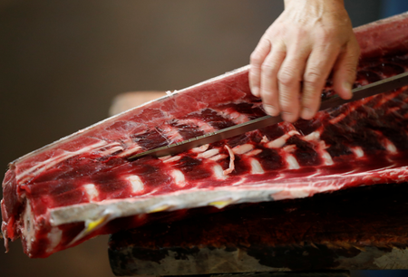 A wholesaler cuts fresh tuna at the Tsukiji fish market in Tokyo, Japan, September 29, 2018. REUTERS/Issei Kato - RC195F745920