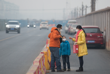 People wearing masks stand in smog during a heavily polluted day in Beijing, China, December 17, 2016. Picture taken December 17, 2016. China Daily/via REUTERS ATTENTION EDITORS - THIS PICTURE WAS PROVIDED BY A THIRD PARTY. EDITORIAL USE ONLY. CHINA OUT. NO COMMERCIAL OR EDITORIAL SALES IN CHINA. - RTX2VHZM