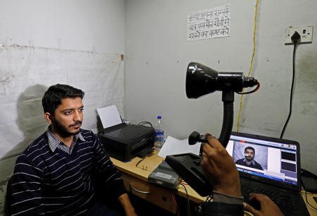 A man goes through the process of eye scanning for the Unique Identification database system, also known as Aadhaar, at a registration centre in New Delhi