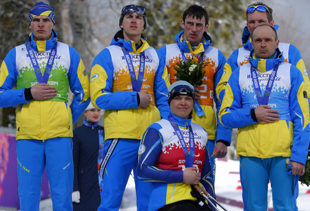 Ukraine&#039;s team, from left: Ihor Reptyukh, Vitaliy Kazakov, Olena Iurkovska, Iurii Utkin, Borys Babar and Vitaliy Lukyanenko cover their silver medals with their hands after finishing second in cross country 4x2.5km open relay at the 2014 Winter Paralympic, Saturday, March 15, 2014, in Krasnaya Polyana, Russia. The majority of Ukraine&#039;s Paralympic medalists covered their medals during medal ceremonies. (AP Photo/Dmitry Lovetsky)