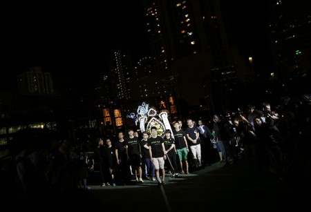 Student protesters walk with wreath during candlelight vigil at Hong Kong&#039;s Victoria Park to commemorate those killed during June 4th military crackdown on pro-democracy movement in Beijing