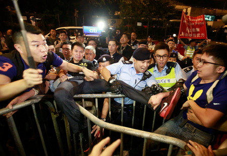 Protesters scuffle with police officers after clashing as thousands of people march in a Hong Kong street, Sunday, Nov. 6, 2016. Thousands of protesters marched in Hong Kong on Sunday, demanding that China&#039;s central government stay out of a political dispute in the southern Chinese city after Beijing indicated that it would intervene to deter pro-independence advocates. (AP Photo/Kin Cheung)