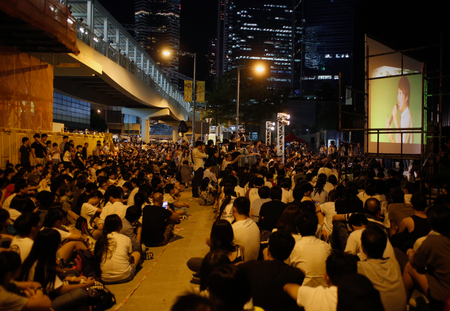 Over a thousand protesters listen to a 14-year-old secondary school student speaking on a podium, shown on a screen, during a rally in Hong Kong September 26, 2014.