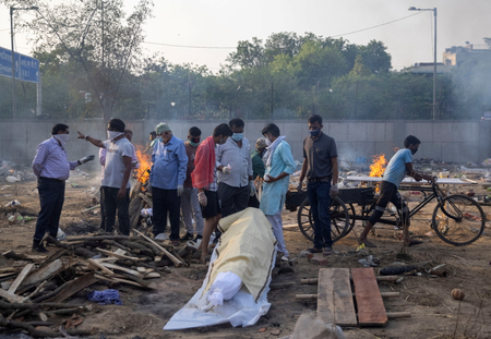 Relatives prepare to cremate the body of a person, who died due to the coronavirus disease (COVID-19), at a crematorium ground in New Delhi