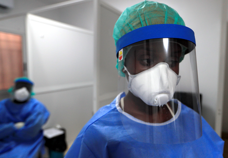 A healthcare worker wearing protective gear stands next to a testing booth for the coronavirus disease at an Institute for Health Research, Epidemiological Surveillance and Training (IRESSEF) testing center, in Dakar.