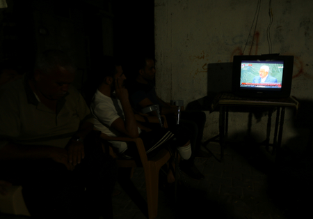 Palestinians watch a television broadcast of Mahmoud Abbas&#039;s speech, in the central Gaza Strip