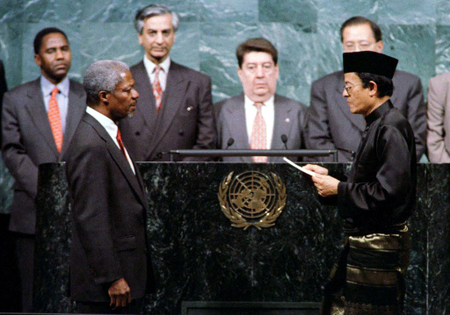 Kofi Annan of Ghana (front L) takes the oath of office as the new United Nations Secretary General from U.N. General Assembly President Razali Ismail of Malaysia (front R) at U.N. headquarters December 17. Kofi Annan is to succeed outgoing Secretary General-Boutros-Boutros-Ghali of Egypt whose term expires December 31. People at rear are unidentified. - PBEAHUMYSDY