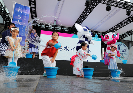 Tokyo 2020 Olympic Games mascot Miraitowa, Paralympic mascot Someity and children splash water during an old Japanese tradition called Uchimizu ritual, meant to cool down the air as the water evaporates, prior to a countdown event to mark the two years until the opening of the Olympic Games Tokyo 2020.