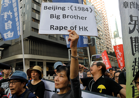 A protester raises a placard as thousands of people march through a downtown street in Hong Kong, Sunday, Nov. 6, 2016, to protest Beijing&#039;s involvement in the recent legislature spat involving two newly elected separatist lawmakers. China&#039;s top legislative panel has said Beijing must intervene in a Hong Kong political dispute to deter advocates of independence for the city, calling such acts a threat to national security. (AP Photo/Vincent Yu)